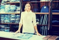 Young female seller demonstrating shirts in menÃ¢â¬â¢s cloths store